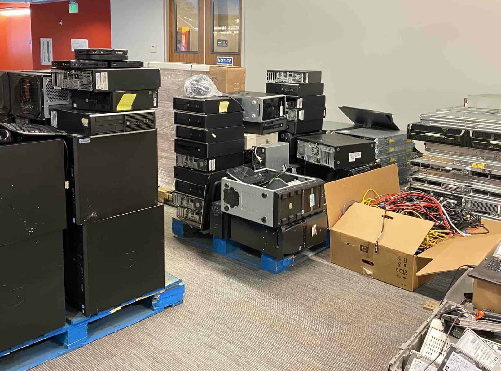 A room full of computers and electronics on pallets.